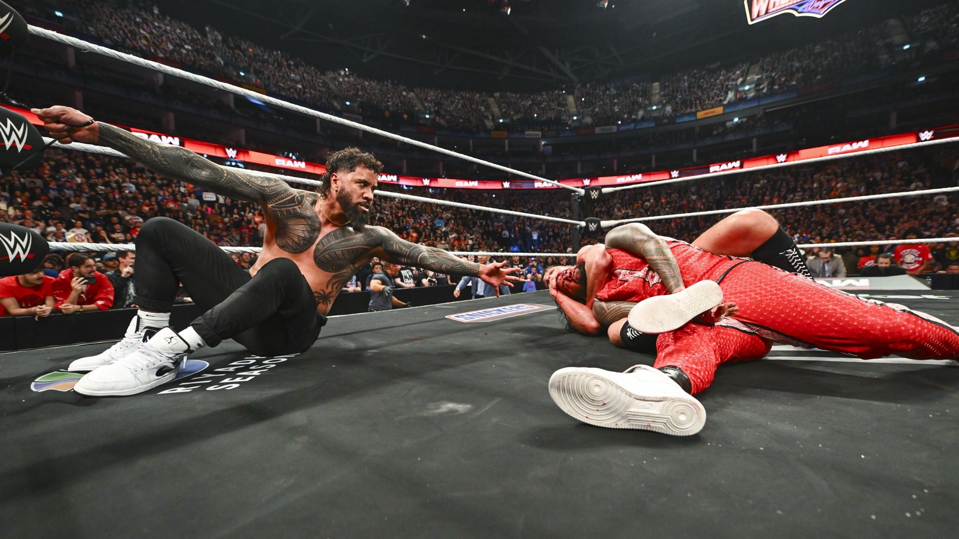 Gunther atacando Jimmy Uso em frente a Jey Uso